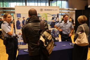 Mitarbeitende der Bundespolizei informieren Besucher am Messestand.